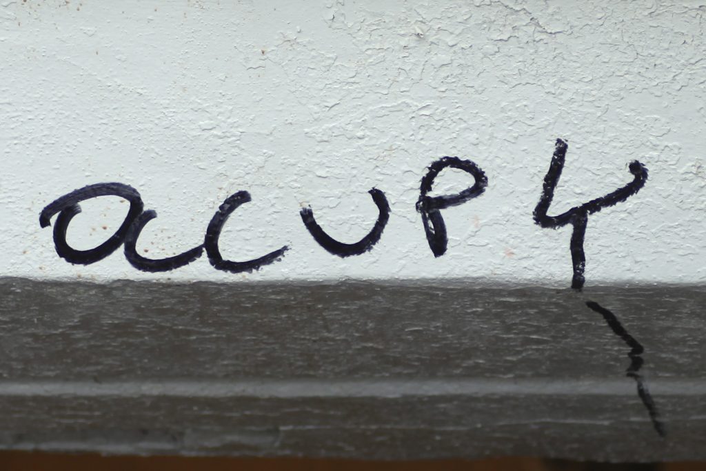 An image of an Occupy sign for our article on 20 Most Important Student Protests on College Campuses