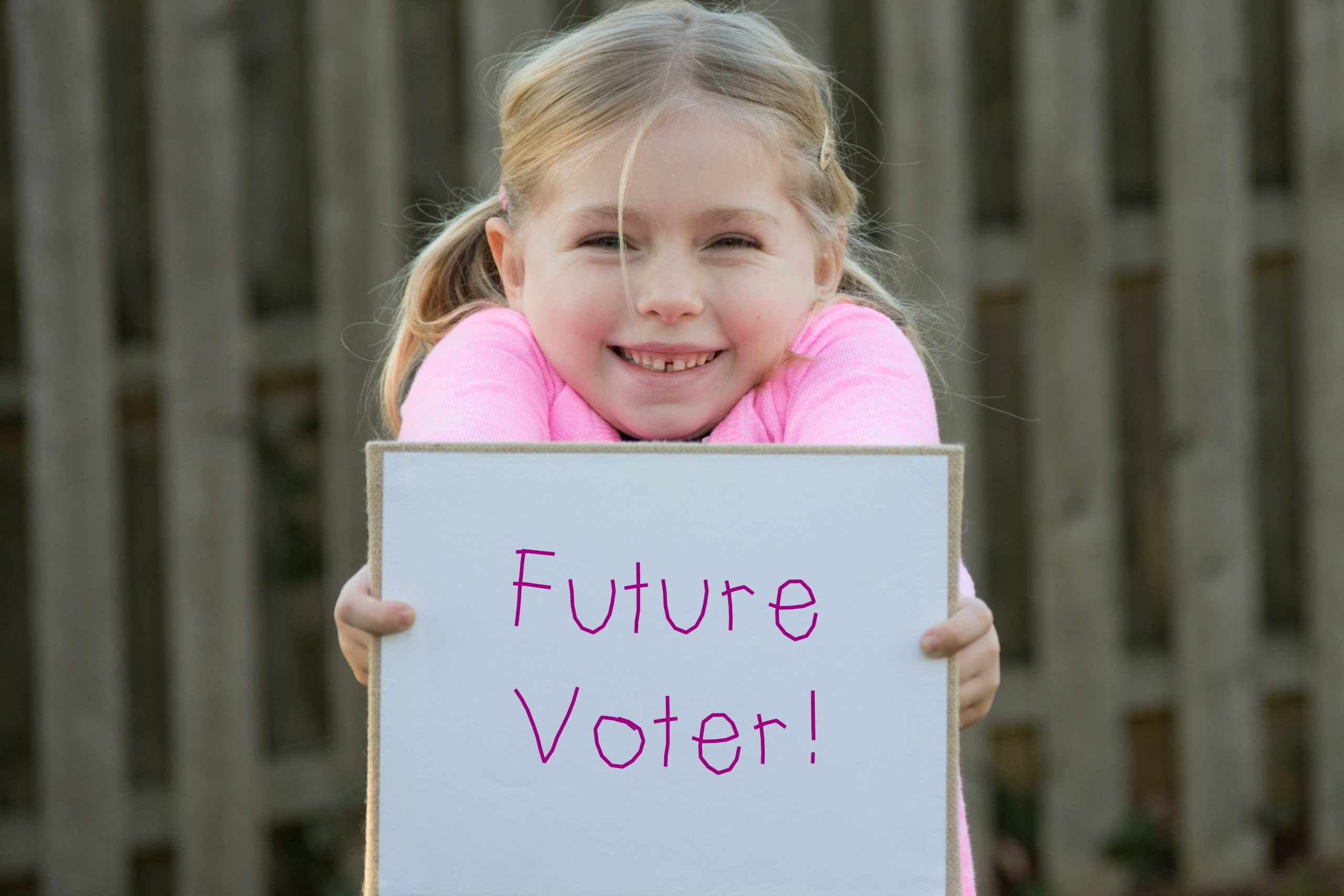 Image of young girl with sign for our FAQ on 30 Books Every Young Democrat Should Own