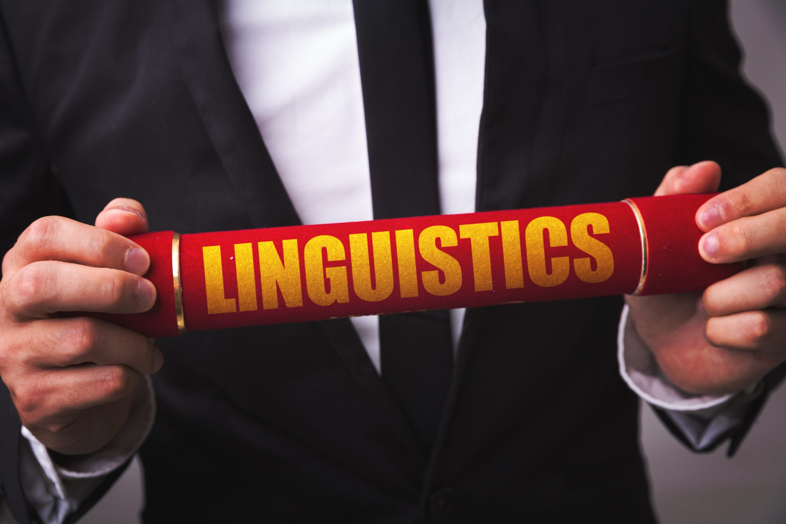Image of a man holding a linguistics sign for our FAQ on What is Psycholinguistics